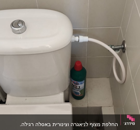 אסלה עם צינור מים מחובר לקיר